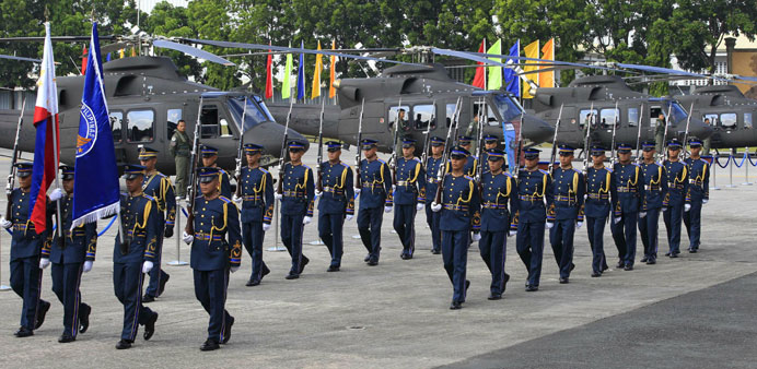 Members of the Philippine air force march in front of newly acquired Bell-412EP helicopters.