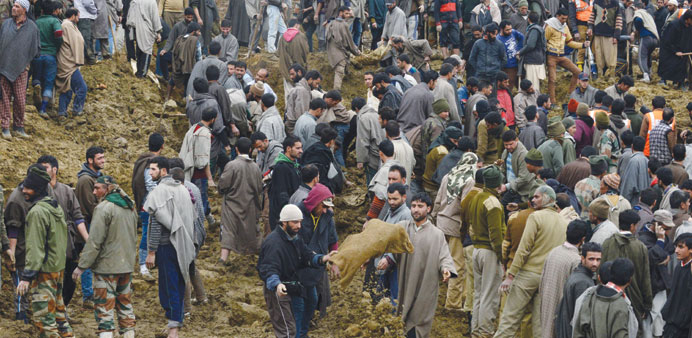 Villagers and officials search for bodies following landslides due to heavy rains in the village of Laden at Chadoora some 40km west of Srinagar yeste