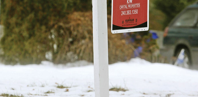 A real estate sign for an existing home stands between melting snow in Silver Spring, Maryland.