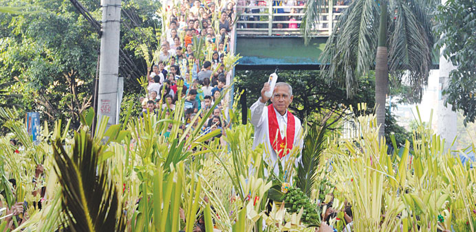 A layman of the Roman Catholic Church (centre) blesses palms during Palm Sunday celebrations in Manila yesterday. Palm Sunday marks the start of the L