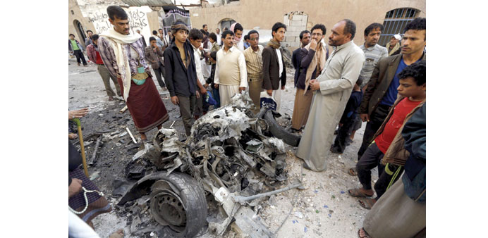People gather at the site of the car bomb attack in Sanaa yesterday.