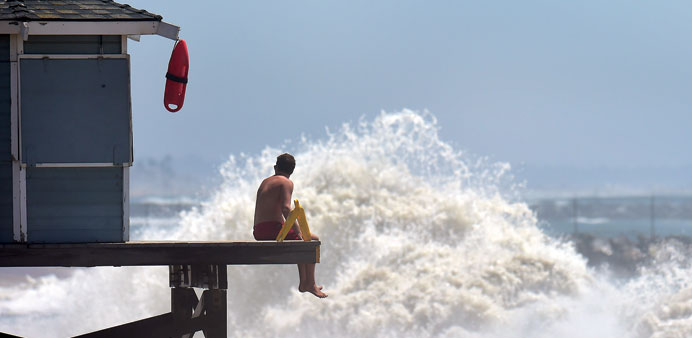 A lifeguard keeps a lookout as big waves crash ashore at Seal Beach, California, where some overnight flooding occurred as the surging ocean water res
