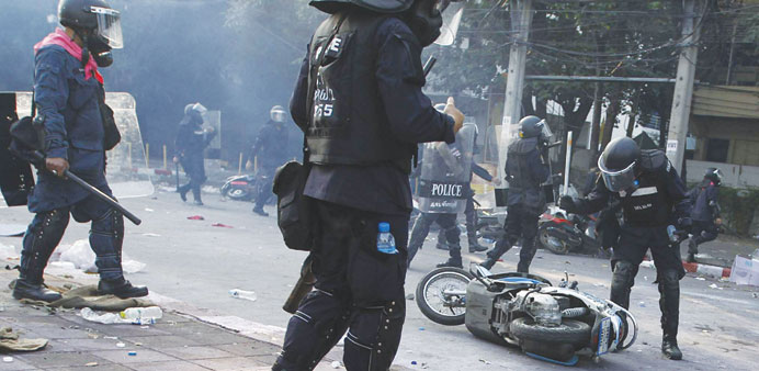 A riot policeman hits a motorcycle belonging to an anti-government protester during clashes outside the Thai-Japan youth stadium in central Bangkok ye