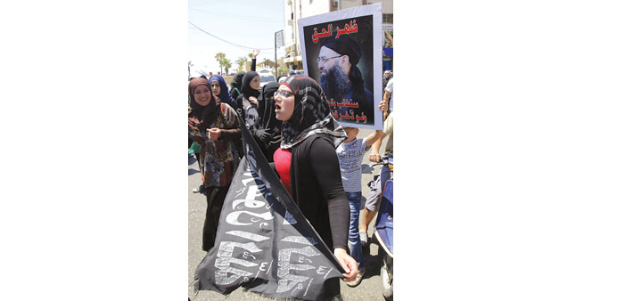 Supporters of Ahmed al-Assir (portrait) demonstrate in the Abra district of Sidon yesterday.