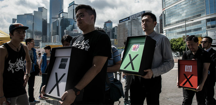 Pro-democracy campaigners display placards symbolising a vote against the government's controversial electoral roadmap