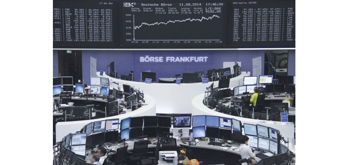 Traders are pictured at their desks in front of the DAX board at the Frankfurt Stock Exchange yesterday. The DAX 30 jumped 1.90% to 9,180.74.