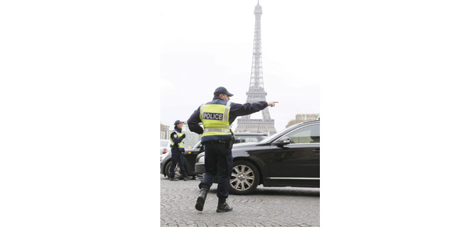 Police officers control cars in front of the Eiffel Tower as Paris resorted to drastic measures to curb soaring pollution levels by forcing all cars w