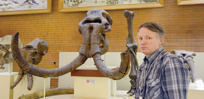 *Russian scientist and mammoth expert Yevgeny Mashchenko surrounded by skeletons and body parts of long-extinct creatures in the instituteu2019s museum.