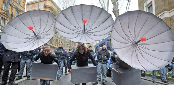Activists hold fake satellite dishes yesterday near the US embassy in Rome to protest the installation of MUOS, an array of communication satellites d