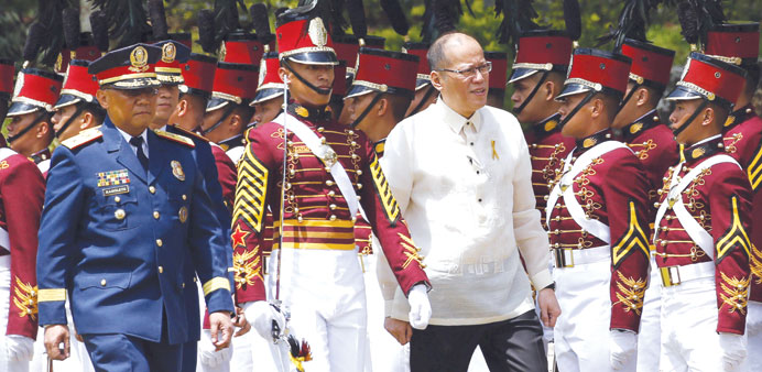President Benigno Aquino (front R) inspects troops during a graduation ceremony for police cadets at the Philippine National Police academy in Silang,