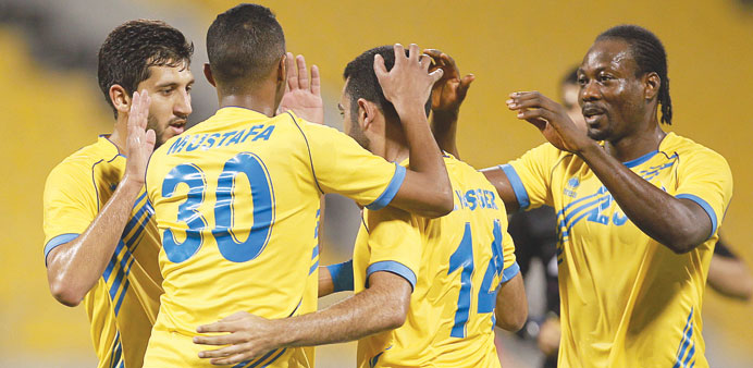  Al Gharafa's Mohamed Yasser is congratulated by teammates after he scored a goal against Al Arabi yesterday.
