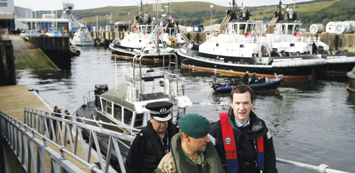 Chancellor of the Exchequer George Osborne arrives at the jetty of the Royal Navyu2019s submarine base at Faslane, Scotland, yesterday.