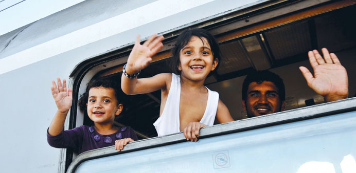 Children wave from a train after boarding it yesterday at the railway station in the village of Ilaca, near the eastern Croatian town of Tovarnik, in 