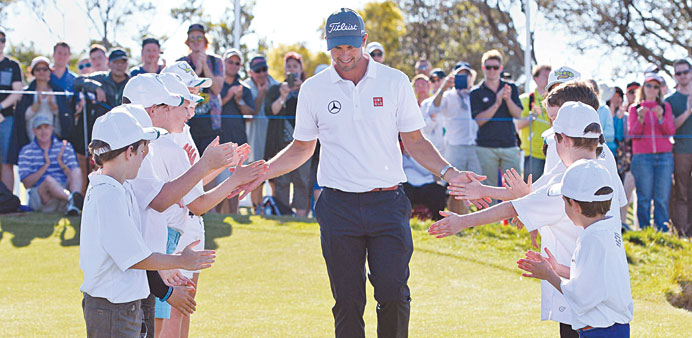 Adam Scott of Australia walks through a guard of honour after defending his Australian Masters golf title, at the Royal Melbourne course yesterday. (A