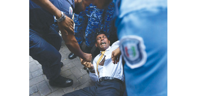 Maldives police trying to move former president Mohamed Nasheed during a scuffle as he arrived at a courthouse in Male yesterday. 