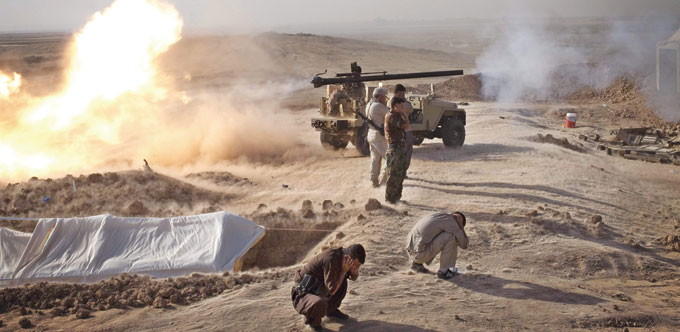 Peshmerga fighters fire cannon towards Islamic State positions during heavy clashes in Duz-Khurmatu yesterday.