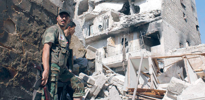    Free Syrian Army fighters standing in front of buildings damaged by  shelling by forces loyal to President Bashar al-Assad in the old city of Alepp