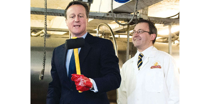 Prime Minister and Conservative party leader David Cameron studies a hammer during a visit to a factory in Wolverhampton, central England, yesterday. 