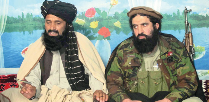 Shahidullah Shahid (right), spokesman of banned Tehrik-e-Taliban Pakistan sits with a local commander Azam Tariq as they speak to journalists at an un