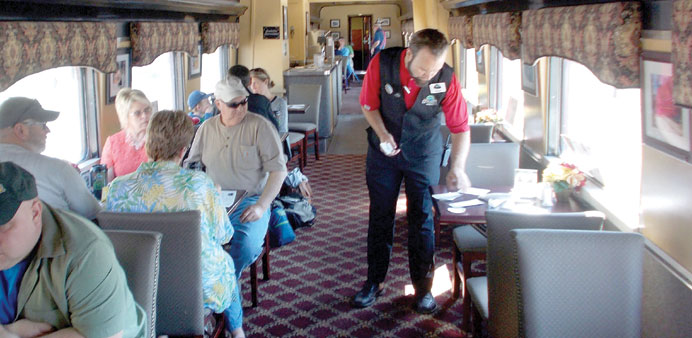 WELCOME ABOARD: A porter sets the table in a dining car on the Great Smoky Mountain Railroad. 