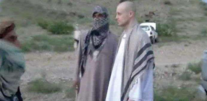 A handout image made available by IntelCenter yesterday showing captured US Army soldier Bowe Bergdahl during his release by Taliban fighters at an un