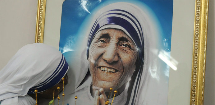 A nun belonging to the order of the Missionaries of Charity kisses a picture of Mother Teresa