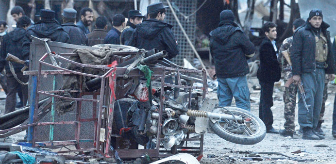 Afghan police walk at the site of a suicide attack in Kabul yesterday.
