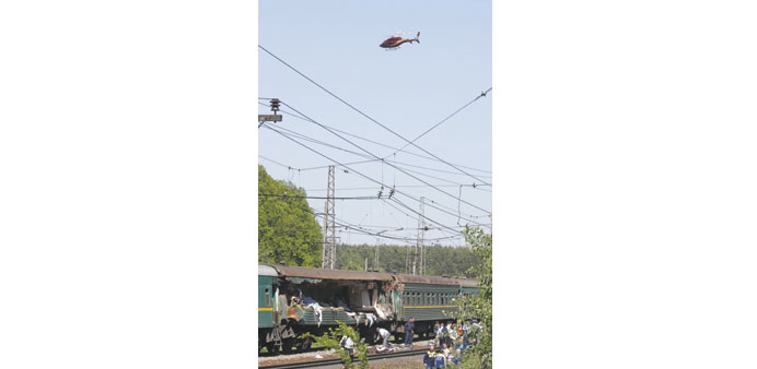 A helicopter flies above the passenger train damaged in a collision with a freight train in Moscow region.