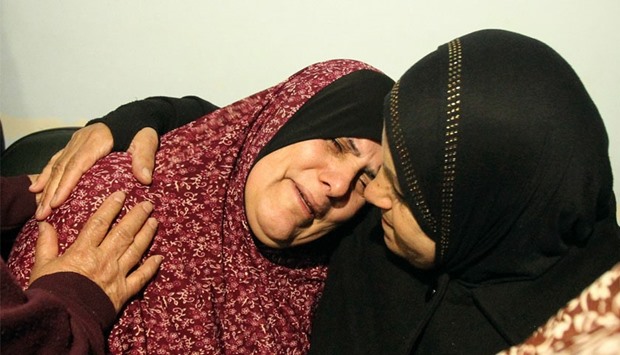 The mother (L) of Palestinian youth Omar Maddi, 16, is comforted by a relative as she mourns the death of her son in the al-Mizan hospital in the West Bank city of Hebron on February 10, 2016 after he was killed during clashes with Israeli security forces in the area of the Al-Arroub refugee camp. AFP