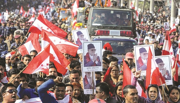 Nepali Congress workers hold photos and party flags during a rally for Sushil Koirala in Kathmandu yesterday.