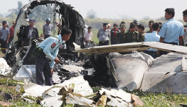 Myanmar army officials inspect the wreckage of a military passenger plane which crashed in a field near the airport in the capital of Naypyidaw yesterday.