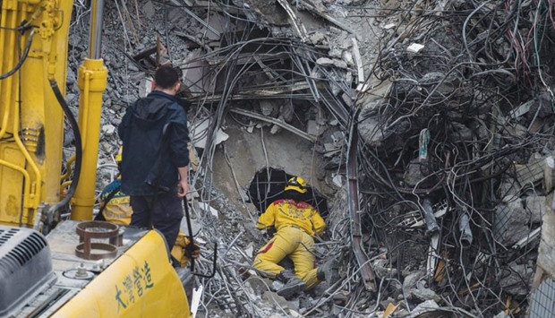 A rescue worker peers into a gap during the search and rescue operation at the Wei-Kuan complex in Tainan.