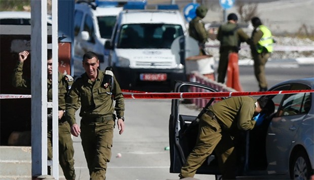 Israeli security forces inspect the place where a Palestinian man who was shot dead