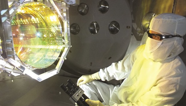 In this handout image, provided by Caltech/MIT/LIGO Lab, shows a Laser Interferometer Gravitational Wave Observatory (LIGO) optics technician inspecting one of LIGOu2019s core optics (mirrors) by illuminating its surface with light at a glancing angle. The first-ever detection of gravitational waves, which scientists could announce today, would open a new window on the universe and its most violent phenomena.