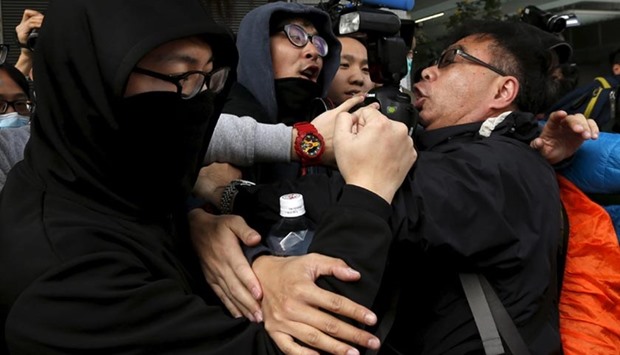 Supporters confront a photographer (right) as they prevent a suspect from being filmed as he leaves to go on bail at a court in Hong Kong on Thursday.