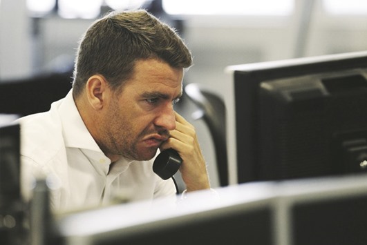 A dealer reacts on the trading floor at financial spread betting company IG Index in London (file). The FTSE is down by around 10% since the start of 2016, and some 20% below a record high of 7,122.74 points reached in April 2015.