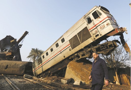 A man walks near the wreckage of a train crash yesterday in Beni Suef, south of Cairo.