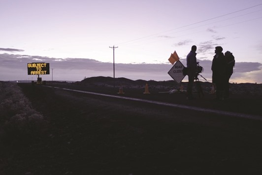 Members of the media wait at a checkpoint about four miles from the Malheur Wildlife Refuge Headquarters near Burns, Oregon.