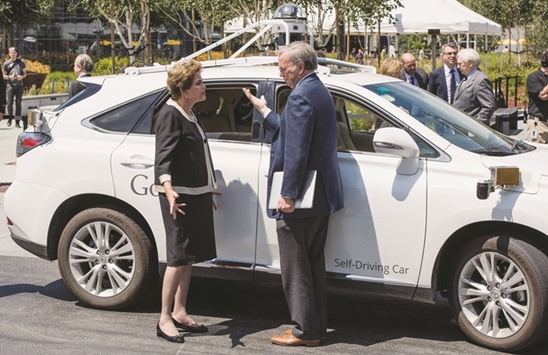 Brazil President Dilma Rousseff (left) speaks to Google chairman Eric Schmidt in front of a Google self-driving car at the companyu2019s headquarters in Mountain View, California, on July 1, 2015. Thirty-six jobs related to the Google X car project were listed on the company web site, including engineers as well as managers.