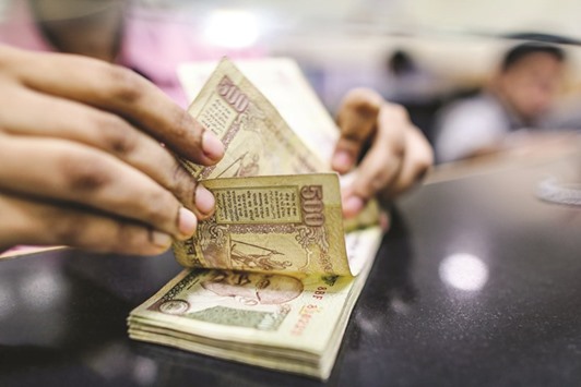 A teller counts Indian rupee banknotes inside a bank branch in Mumbai. The rupee is a casualty of the broader selloff in emerging markets thatu2019s coinciding with fading confidence in Prime Minister Narendra Modiu2019s ability to push through economic changes including a goods-and-services tax thatu2019s currently deadlocked in parliament.