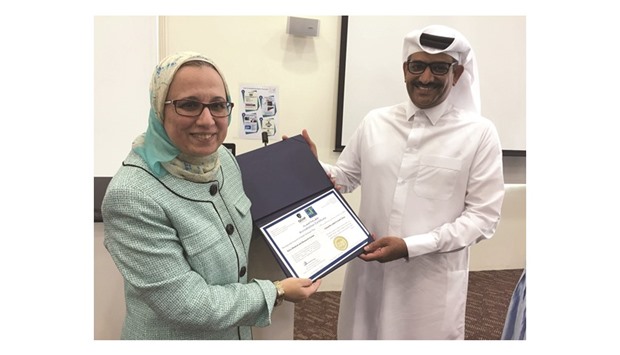 Dr Samar Aboulsoud handing over the CME/CPD accreditation certificate to Dr Abdulla al-Kaabi.