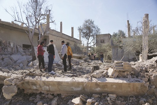 People inspecting the damage after air strikes by pro-government forces in the rebel-held town of Dael, in Deraa Governorate, Syria yesterday.