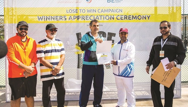 Dr al-Mulla honours a winner of the u2018Lose to Winu2019 programme.