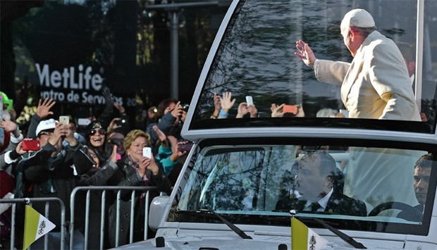 Pope Francis waves from the popemobile on his way to the National Palace, in Mexico City