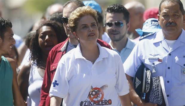 Brazil's President Dilma Rousseff (C) walks with residents during a visit to their neighborhood on t