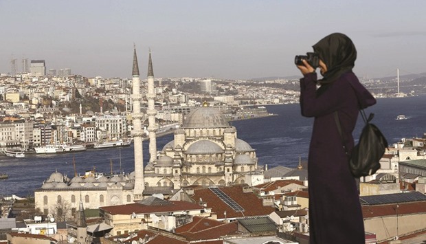 A tourist takes photographs in front of the New Mosque by the Bosphorus strait in Istanbul. The central bank reported on Thursday that u201cnet errors and omissionsu201d rose to $9.7bn. One possible cause is the difference between actual tourism revenue and the amount estimated by the bank, which relies on surveys of foreign visitors.