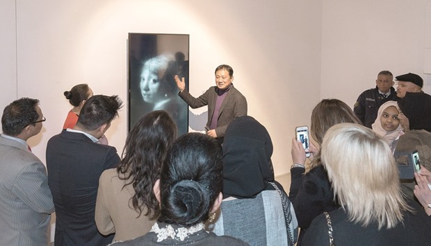 EXPLANATION: Lee Nam talks to visitors about his reinterpretation of Johannes Vermeeru2019s Girl with a Pearl Earring, in which he extracts our sympathy by introducing tears into the frame.