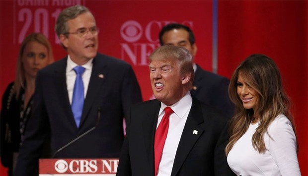 Republican US  presidential candidate former Governor Jeb Bush (rear) walks past rival candidate businessman Donald Trump and his wife Melania (R) as they stand at the front of the stage at the conclusion of the Republican US presidential candidates debate sponsored by CBS News and the Republican National Committee in Greenville, South Carolina.