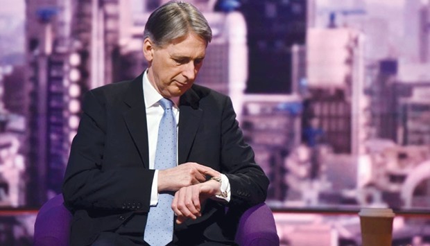 Foreign Secretary Philip Hammond looks at his watch while appearing on BBCu2019s Andrew Marr Show in London yesterday.