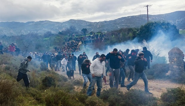 Tear gas is fired as people protest against the so-called ,hotspot, being built for refugees and migrants on the Aegean island of Kos